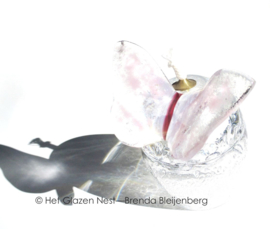 Licht roze vlinder op olielampje van mond geblazen glas