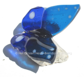 blauwe glazen vlinder met witte stippen