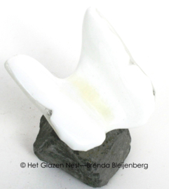 Witte vlinder in glas op basalt steentje