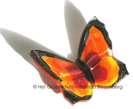 Vlindertje in oranje glas met zwarte randen