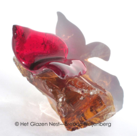 Kleine rode vlinder op ruw amberkleur glas