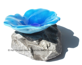 speelse abstract bloem in aqua blauw glas op steen