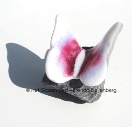 Vlinder op steen in wit en roze