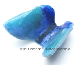 Kleine speelse vlinder in groenblauw glas