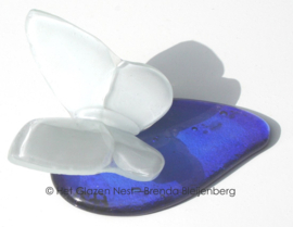 Witte vlinder op blauwe druppel van glas
