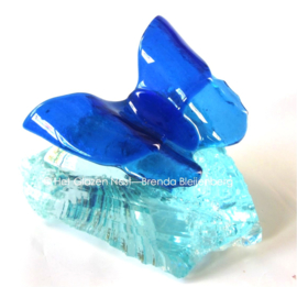 blauwe vlinder op glasbrok
