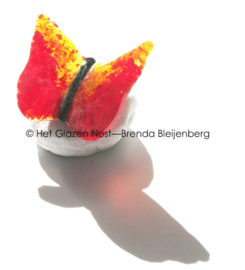 Kleine rood en gele vlinder van glas