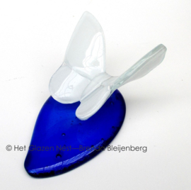 Witte vlinder op blauwe druppel van glas