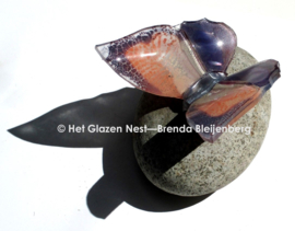 Bijzondere glazen vlinder op steen