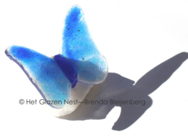 Kleine blauwe vlinder op ruw bergkristal