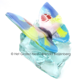 pastel kleurige vlinder op glas brok