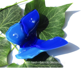 Blauwe vlinder met enkele witte stippen op de vleugeldelen, ondoorzichtig glas