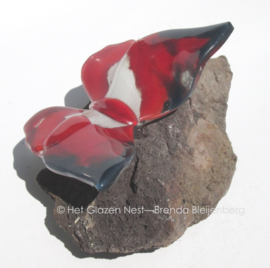 rode vlinder met zwart en witte accenten op lavas