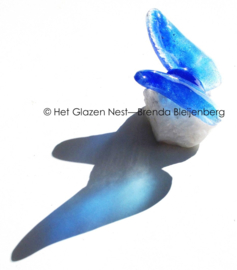 Kleine blauwe vlinder op ruw bergkristal