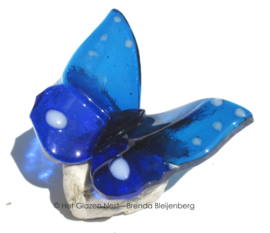 blauwe glazen vlinder met witte stippen