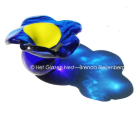 Kleine blauwe bloem op blauw glazen bolletje