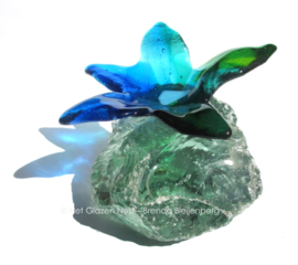 blauwe groene bloem op glasbrok