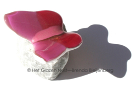 Kleine roze glazen vlinder op steentje