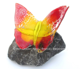 Glazen vlinder op basalt steen