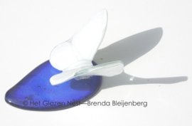 Witte vlinder op blauwe druppel van glas
