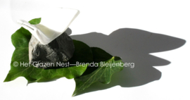 Witte vlinder in glas op basalt steentje