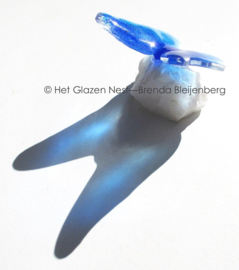 Kleine blauwe vlinder op ruw bergkristal