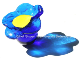 Kleine blauwe bloem op blauw glazen bolletje