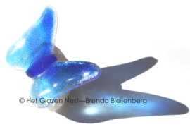 Kleine blauwe vlinder op ruw bergkristal