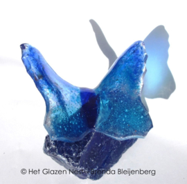 klein dansend blauw vlindertje op glas