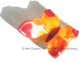 Kleine oranje vlinder met rode accenten