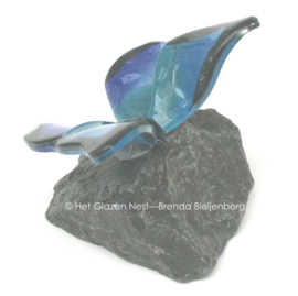 Glazen vlinder op basalt steen