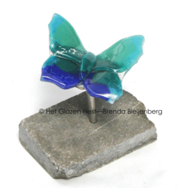 Kleine blauw groene vlinder op ruwe steen