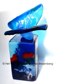 Blauwe glazen vlinder op gekleurde urn-zuil