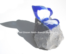 Wit en blauwe vlinder op grijs basalt