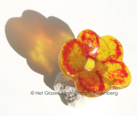 Glazen bloemetje op steen