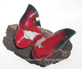 rode vlinder met zwart en witte accenten op lavas