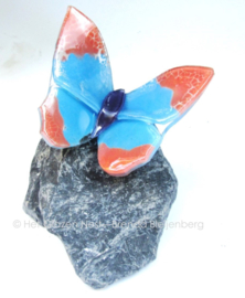 Roze en blauw vlindertje op grijze basalt