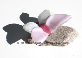 Roze en witte vlinder op steentje