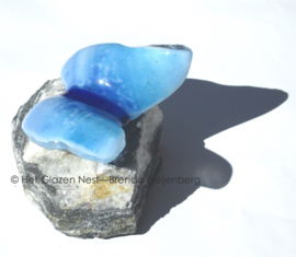 Speelse glas vlinder op ruwe steen