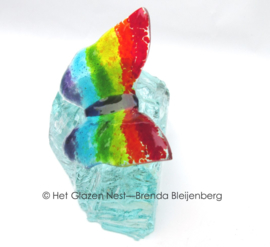 Regenboog vlinder op glasbrok