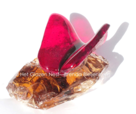 Kleine rode vlinder op ruw amberkleur glas