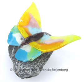 vlinder in pastel kleuren op basalt steen