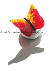 Kleine rood en gele vlinder van glas