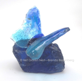 klein dansend blauw vlindertje op glas