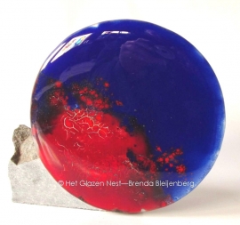 Cirkel in volle blauw en roodtinten, tegen een stuk graniet