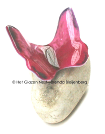 Roze glazen vlinder op kei