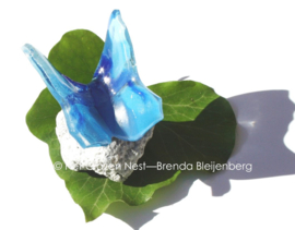 Blauwe vlinder van glas op steentje