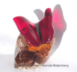 Kleine rode vlinder op ruw amberkleur glas