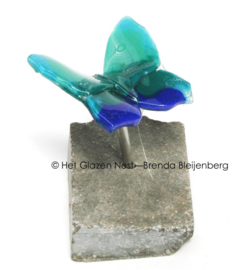 Kleine blauw groene vlinder op ruwe steen