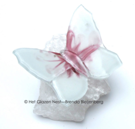 Witte vlinder met roze accenten op bergkristal
